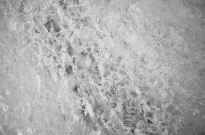 Close-up image of a frosty, icy surface. The intricate crystalline patterns form a textured landscape of ice, reminiscent of the complex designs found in an Ice Watch collection. Various shapes, lines, and formations create a visually engaging natural design with a cool and monochromatic color tone.