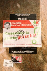 A poster on a wall in Paris promotes a march against racism, police violence, the mafia, and migrant hunting, organized by Ensemble Insoumis with Jean-Luc Mélenchon. There's a slogan "Rassembler la gauche qui se bat," contact info, social media handles, and event details as part of their campagne.