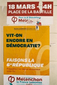 A wall in Paris covered with political posters in French. The top poster has a red background reading "18 MARS – 4H, PLACE DE LA BASTILLE." The middle poster reads "VIT-ON ENCORE EN DÉMOCRATIE? FAISONS LA 6E RÉPUBLIQUE." The bottom poster displays "Mélenchon La France insoumise