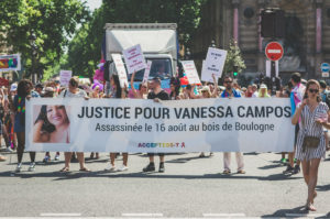 A group of people march in a street protest holding a banner that reads "Justice pour Vanessa Campos, assassinée le 16 août au bois de Boulogne" with the ACCEPTESS-T logo. Other protest signs are visible in the background.