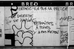 Graffiti-covered wall with messages in French, including “CEDRIC TUE PAR LA POLICE DE DELEVOYE + DE KOALAS” and “RETRAITES A POINTS Y A PAS MOYEN.” The wall, likely from a manifestation on 11 Janvier 2020 against the réforme des retraites, has tags, drawings, and scribbles, with parts of a