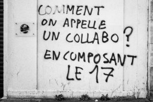 Graffiti in French on a wall reads, "COMMENT ON APPELLE UN COLLABO? EN COMPOSANT LE 17," which translates to "How do you call a collaborator? By dialing 17." There is also a small sign with the word "P, Chave" on the left side of the image. This scene evokes memories of the manifestation against the réforme des retraites